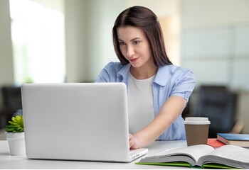 Cheerful business lady working on laptop in office. Attractive female employee office worker smile.