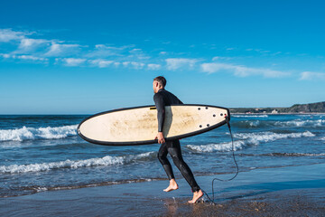 Middle-aged man running into the sea.