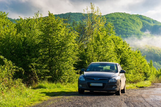 turya, ukarine - MAY 17, 2021: car on a country road in the morning. beautiful landscape in the rural valley on a sunny morning. travel countryside and spring vacation concept