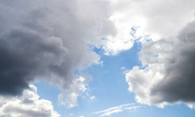 Summer sky. Cumulus clouds on a blue background. Partly cloudy.