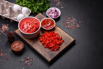 Ingredients for making shakshuka, dishes with fried eggs with tomato sauce, spices and herbs