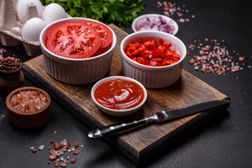 Ingredients for making shakshuka, dishes with fried eggs with tomato sauce, spices and herbs