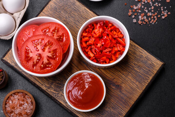 Ingredients for making shakshuka, dishes with fried eggs with tomato sauce, spices and herbs