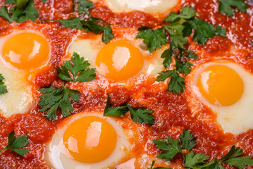 Shakshuka, a dish with fried eggs with tomato sauce, sweet pepper, garlic, onions, spices and herbs