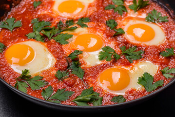Shakshuka, a dish with fried eggs with tomato sauce, sweet pepper, garlic, onions, spices and herbs
