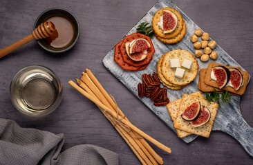 Food photography of wine, soft cheese, salami, figs, crackers, feta, grissini