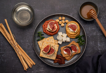 Food photography of wine, soft cheese, salami, figs, crackers, feta, grissini