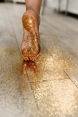 Legs in glitter. The girl walks on gold. The girl at the New Year's party goes for confetti.