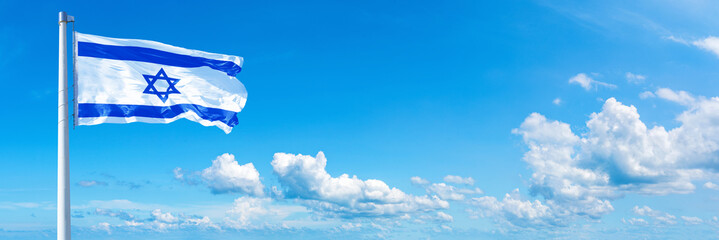 Israel flag waving on a blue sky in beautiful clouds - Horizontal banner
