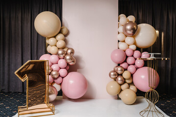 Arch decorated with pink, brown, and gold balloons. Copy space. Birthday arch for 1 year and a...