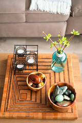 Home interior - bowls with stones, candles and blue bottle with spring branches