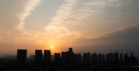 Fototapeta na wymiar City buildings under sunset sky
