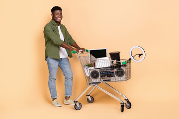 Photo of guy push cart have different items sell garage sale wear denim jeans isolated pastel color background
