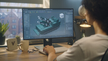 Male designer creating 3D model of missile launcher using professional 3D modeling program on...