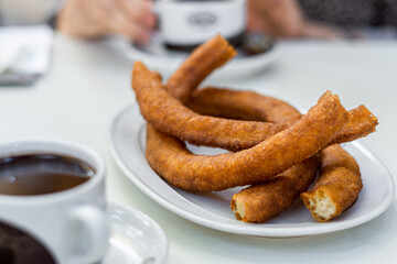 Baked churros ready to eat, on a white tray