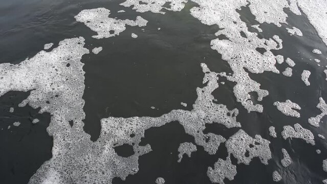 video of foam on water, fast flowing showing the pollution of the environment