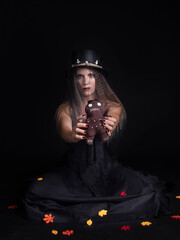 young woman showing a voodoo doll at halloween
