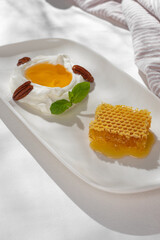 White Greek yogurt with honeycomb - traditional greek dessert - light healthy natural dietetic snack or meal.
