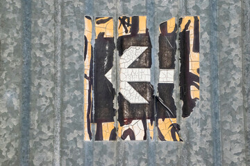 Damaged and weathered direction sign sticker with white arrow pointing to the left on a metal surface. Urban  industrial graphic minimal signs.  © Marjolein Hameleers
