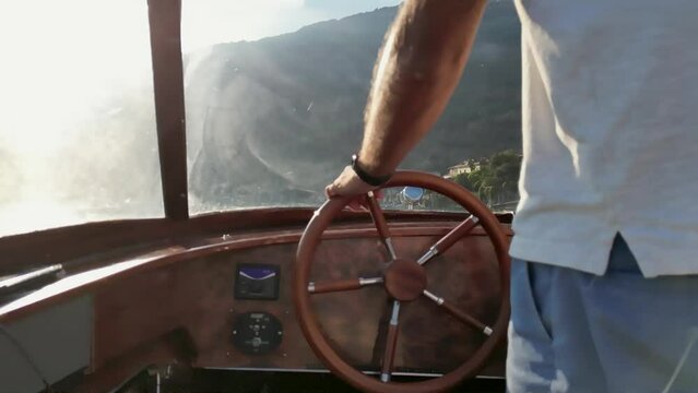 Close Up of a man using a Stearing Wheel on Como Lake