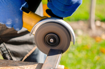 Close-up on the sides fly bright sparks from the angle grinder machine