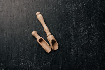 Two spoons on a black background. Wooden tableware