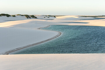 Beautiful view to blue rain water lagoon and white sand dunes