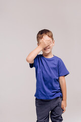 boy wearing blue t-shirt on grey