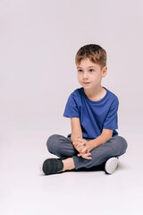 boy wearing blue t-shirt on grey