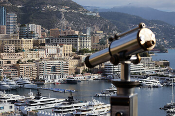 Monaco, Monaco - 02.10.2022: Morning view of the Principality of Monaco from the Prince's palace, with a telescope in the foreground, partly out of focus