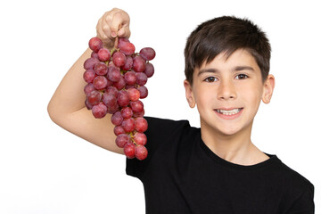 Photo of adorable young happy boy looking at camera.Isolated on the white background. Healthy little boy eating grapes