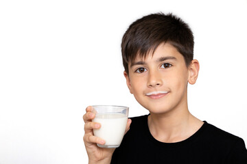 Photo of adorable young happy boy looking at camera.Cute kid drinking milk on white background