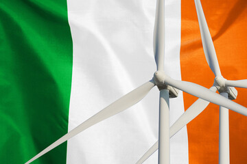 Two Wind Turbines for alternative energy on Ireland flag background. Energy development and energy...
