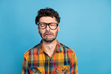 Photo of stressed brunet guy cry wear eyewear plaid shirt isolated on blue color background