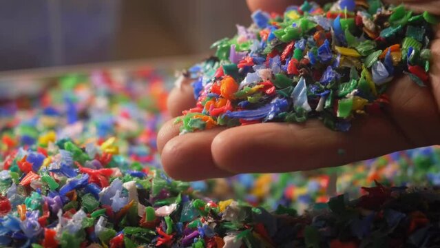 colorful plastic fragments close up, plastic waste, plastic pollution, environment. microplastics in hands. pieces of microplastic in the world's oceans. plastic recycling concept