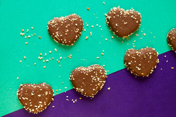 chocolate cookies hearts with nuts on colorful background. flat lay on colored paper. Chocolate chips