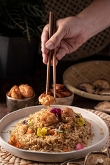 hand eating asian food with chopsticks