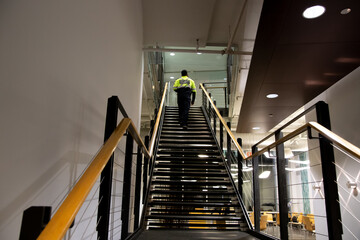 A security guard is patrolling an office at night.