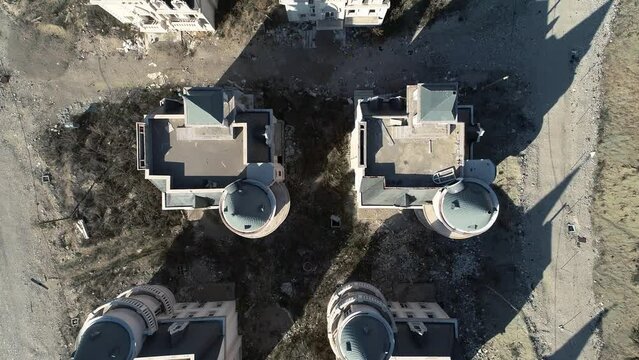 Houses which are being built in style of mini French chateaux, all three storeys tall with a round corner turret and square tower above their entrances. Aerial, fly over