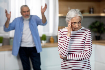 Domestic Abuse. Angry Senior Man Shouting At His Crying Wife In Kitchen