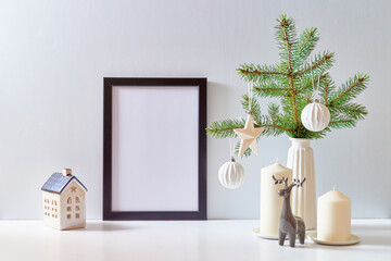 Mock up black poster frame with christmas decoration in home interior, scandinavian style. Green...