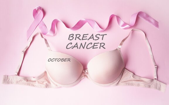 On a pink background, the emblem is a satin pink ribbon, a women's bra.  Breast cancer notice poster.  The concept of healthcare and medicine.  Close-up.