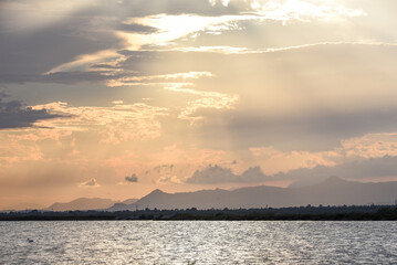 Beautiful colorful sunrise at sea with dramatic clouds and bright sun