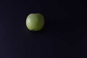 Fototapeta na wymiar Falling green apple on a black background. isolated