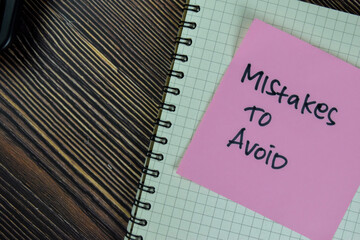 Concept of Mistakes to Avoid write on sticky notes isolated on Wooden Table.