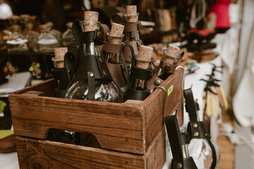 Wooden box of potion bottles with (leather holders) on a market stall, bottles for cosplay costumes