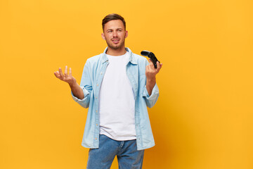 Confused unhappy tanned handsome man in blue basic t-shirt raise hands up with joystick gamepad...