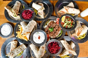 Delicious meat kebab with fresh vegetable salad served with variety of Turkish dishes and appetizers. Top view of assorted Turkish food and meze, tasty and healthy Mediterranean cuisine.