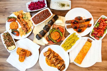 Delicious meat kebab with fresh vegetable salad served with variety of Turkish dishes and appetizers. Top view of assorted Turkish food and meze, tasty and healthy Mediterranean cuisine.