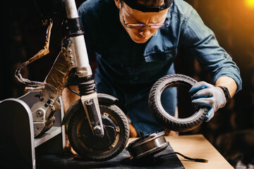 repair of an electric scooter in a workshop, replacement of a tire on a wheel. © velimir